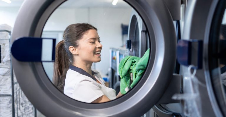 Auszubildende wäscht Wäsche für die Hauswirtschaft