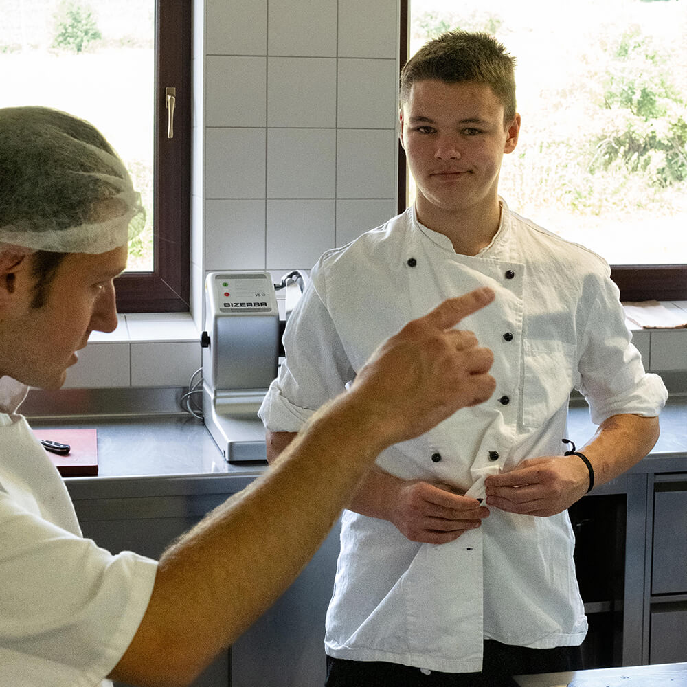 Azubi in weißer Kochschürtze